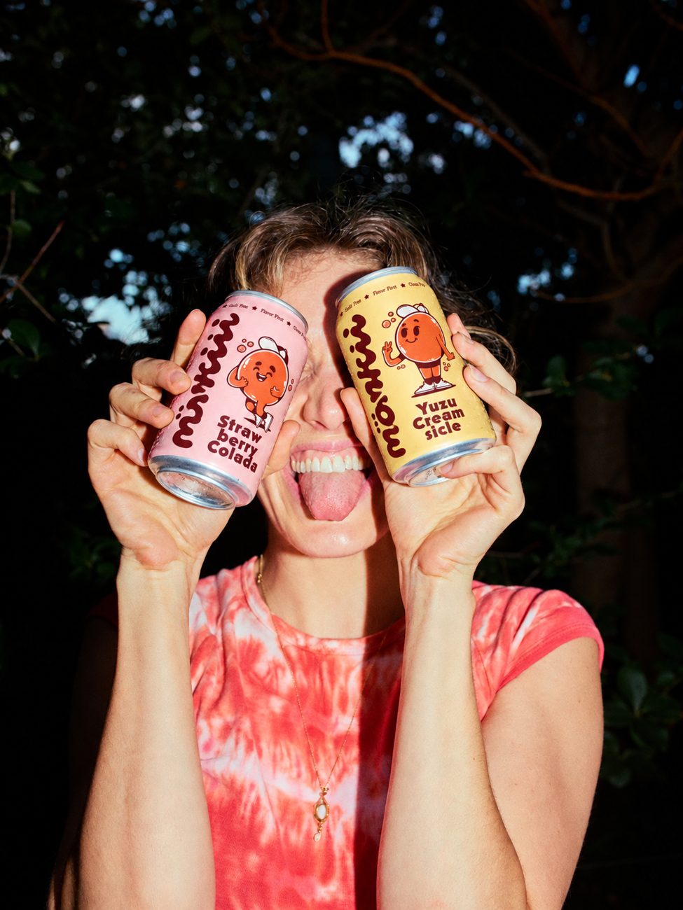 Person holding both mönkii cans over their eyes, tongue out