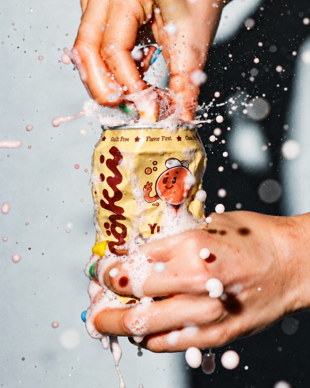 Hands cracking open a fizzing Yuzu Creamsicle can